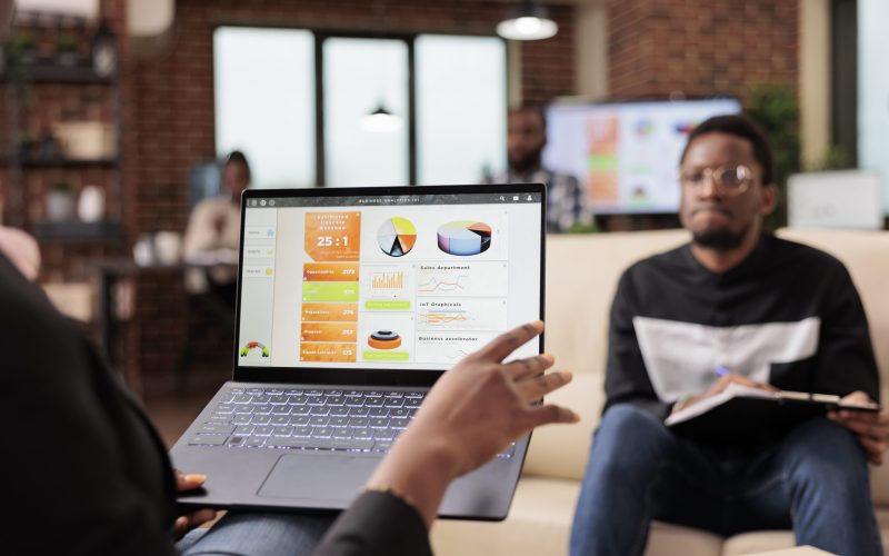 African american business people analyzing company charts and diagrams on laptop to create startup presentation and paperwork report. Doing teamwork collaboration to plan research information.